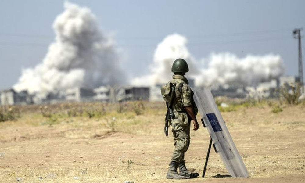 Soldado turco observa desde Suruc, Turquía, los combates del otro lado de la frontera. //bbc.com 