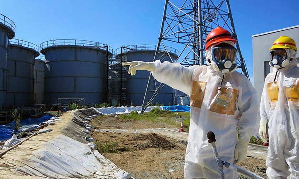 Trabajadores de Tokyo Electric Power Company (TEPCO) inspeccionan los edificios de los reactores 1-4 (dcha) en la central de Fukushima Daiichi (Japón). //EFE