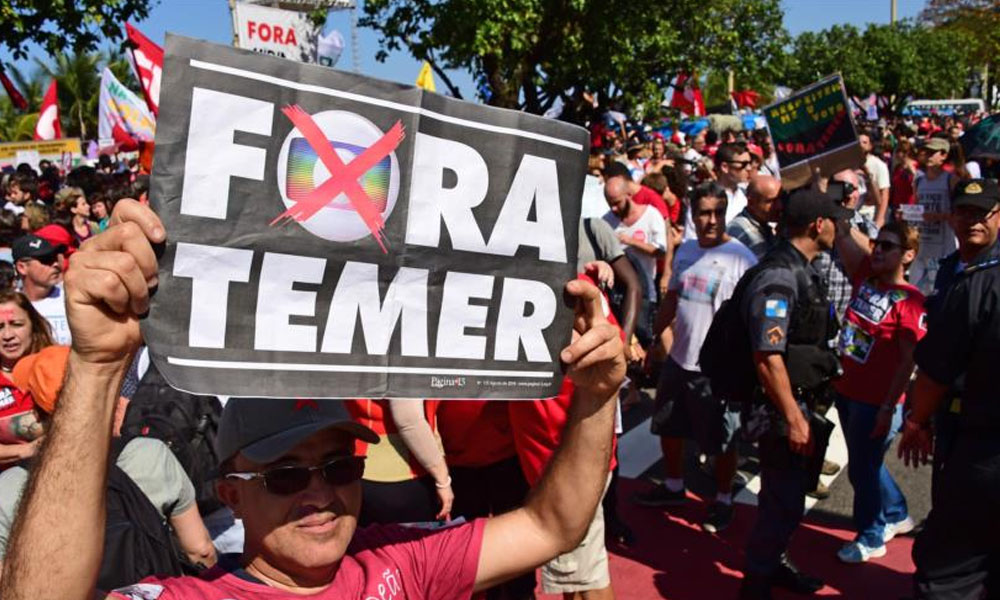 Un brasileño porta un cartel en señal de rechazo al presidente interino del país, Michel Temer. //hispantv.com