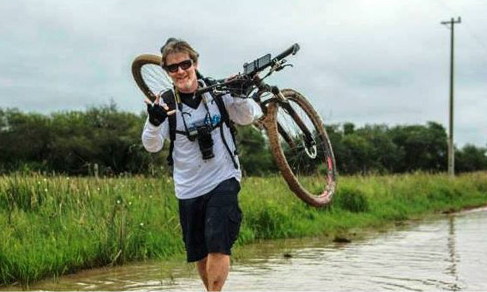 El joven atraviesa por tramos difíciles con una bicicleta.