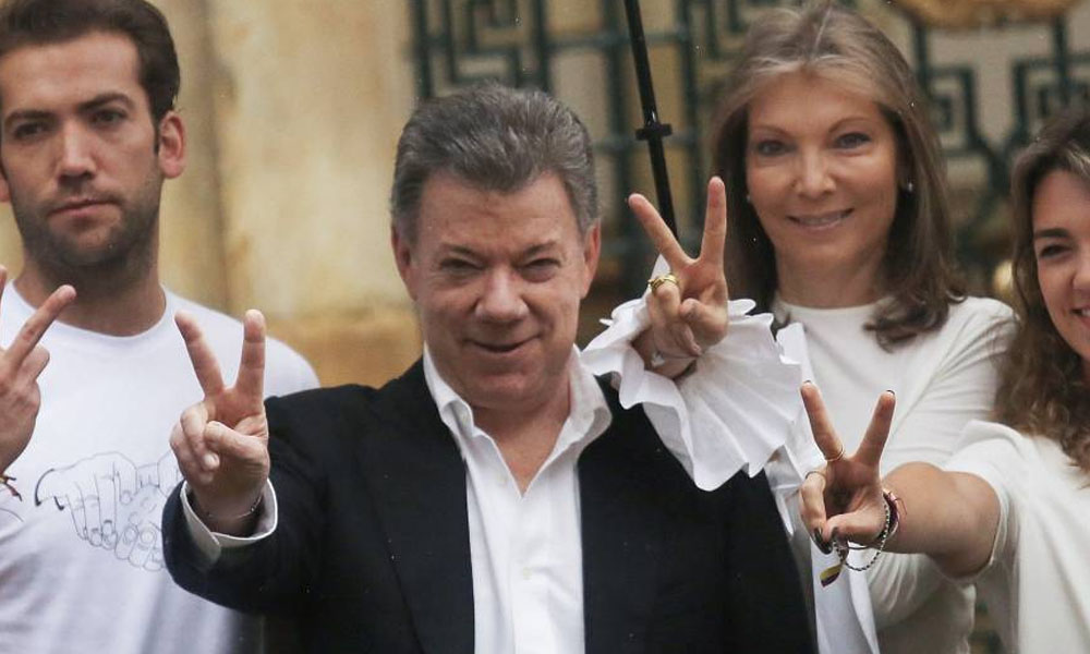 Juan Manuel Santos hace el signo de la victoria tras depositar el voto en el referéndum sobre los acuerdos de paz. //elpais.com