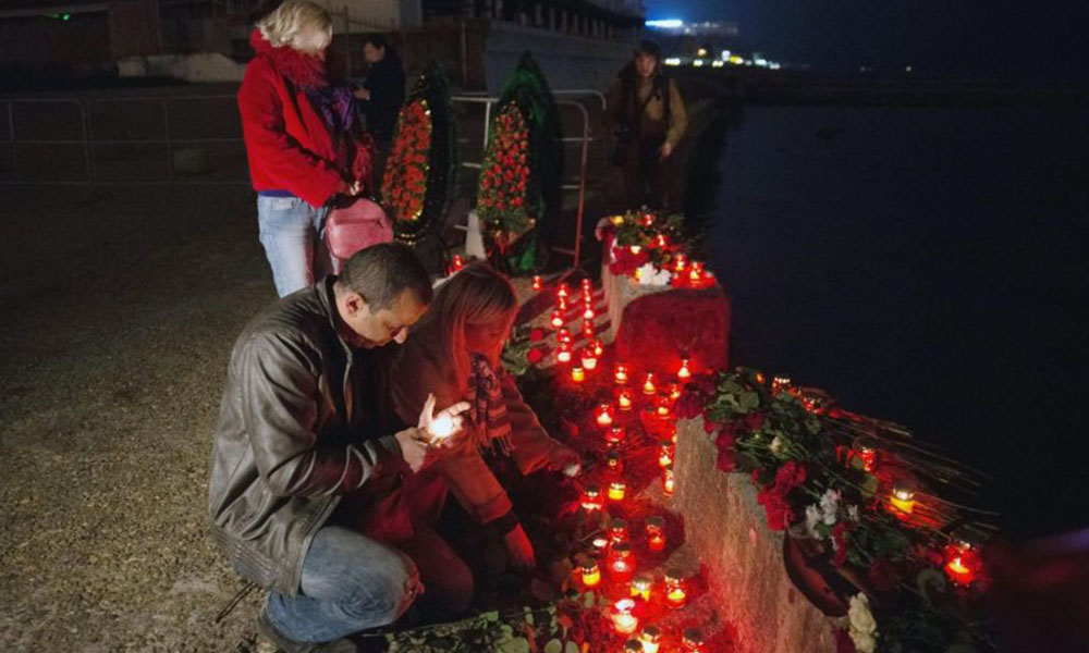 Varias personas en la ciudad rusa de Sochi encienden velas en homenaje a alas victimas del siniestro.